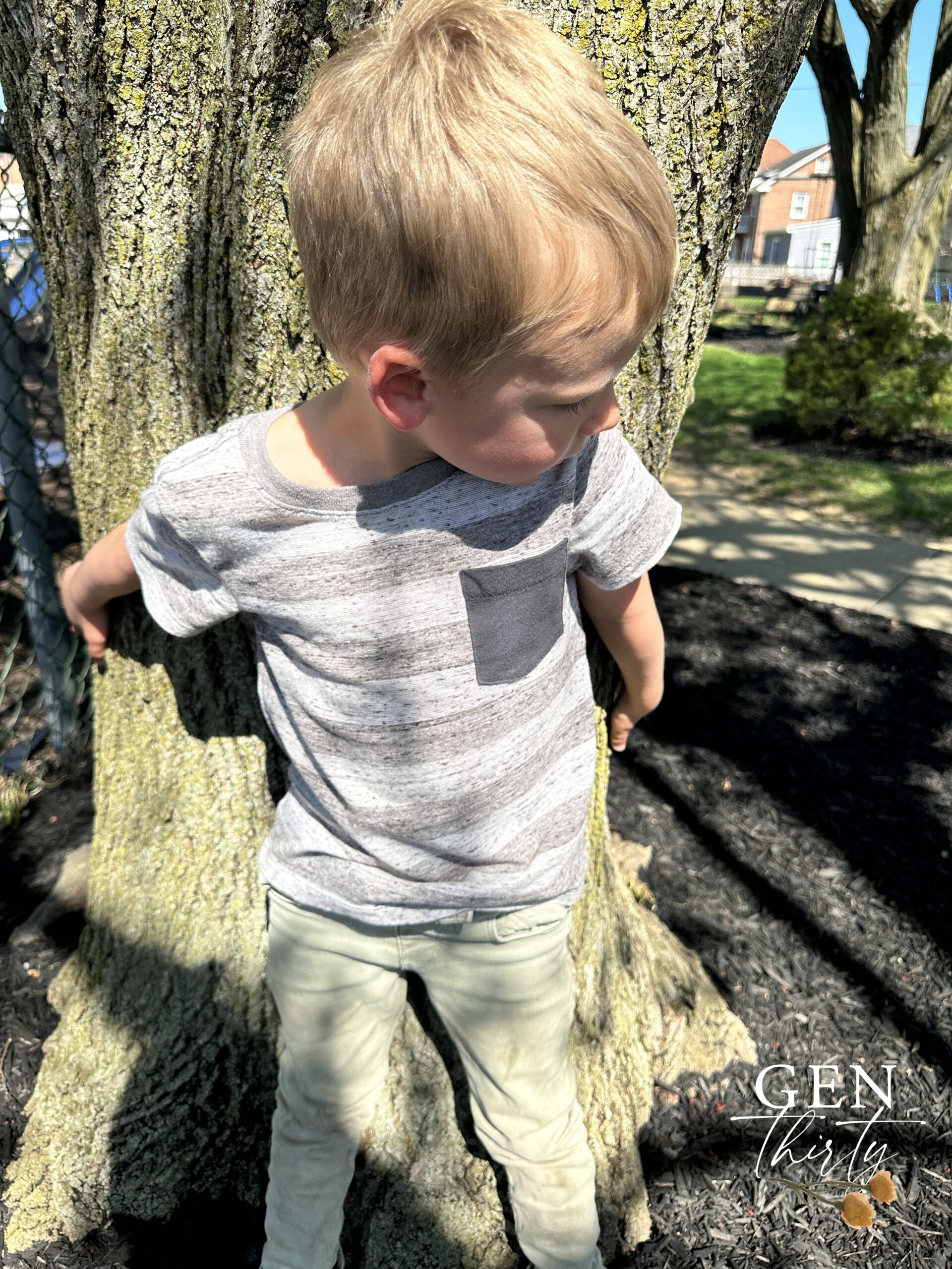 blonde boy hugging a tree for earth day 