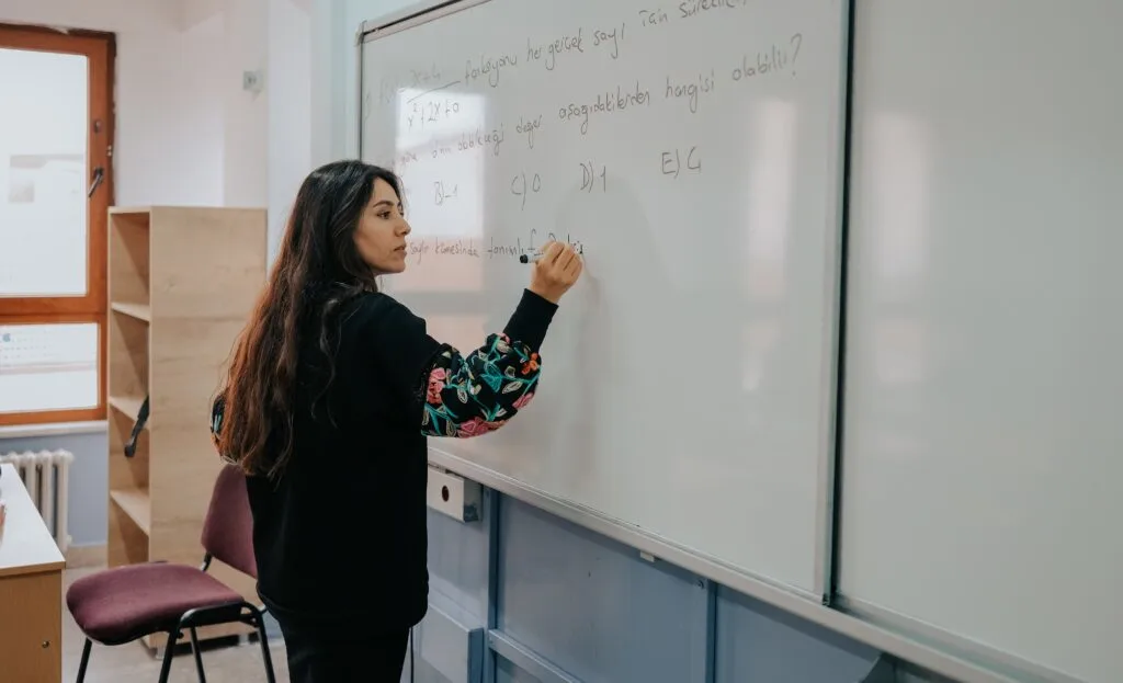 teacher writing on whiteboard