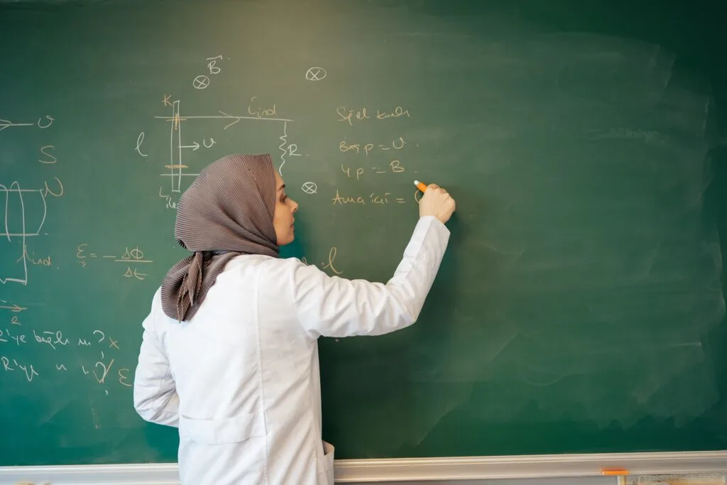 teacher writing on chalkboard